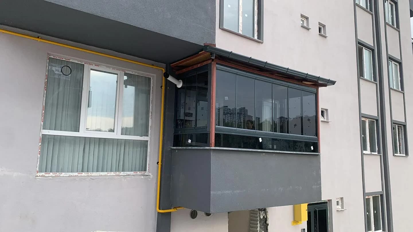 Apartman üst katında ahşap çerçeveli füme camlı katlanır cam balkon uygulaması Samsun