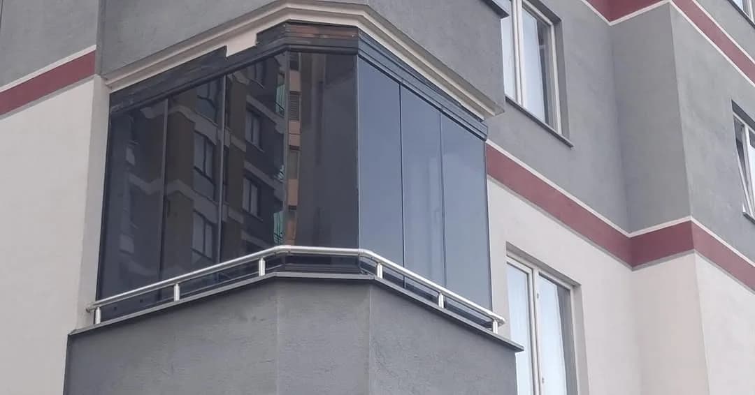 Samsun'da apartman köşe balkonuna uygulanmış füme gri katlanır cam balkon sistemi