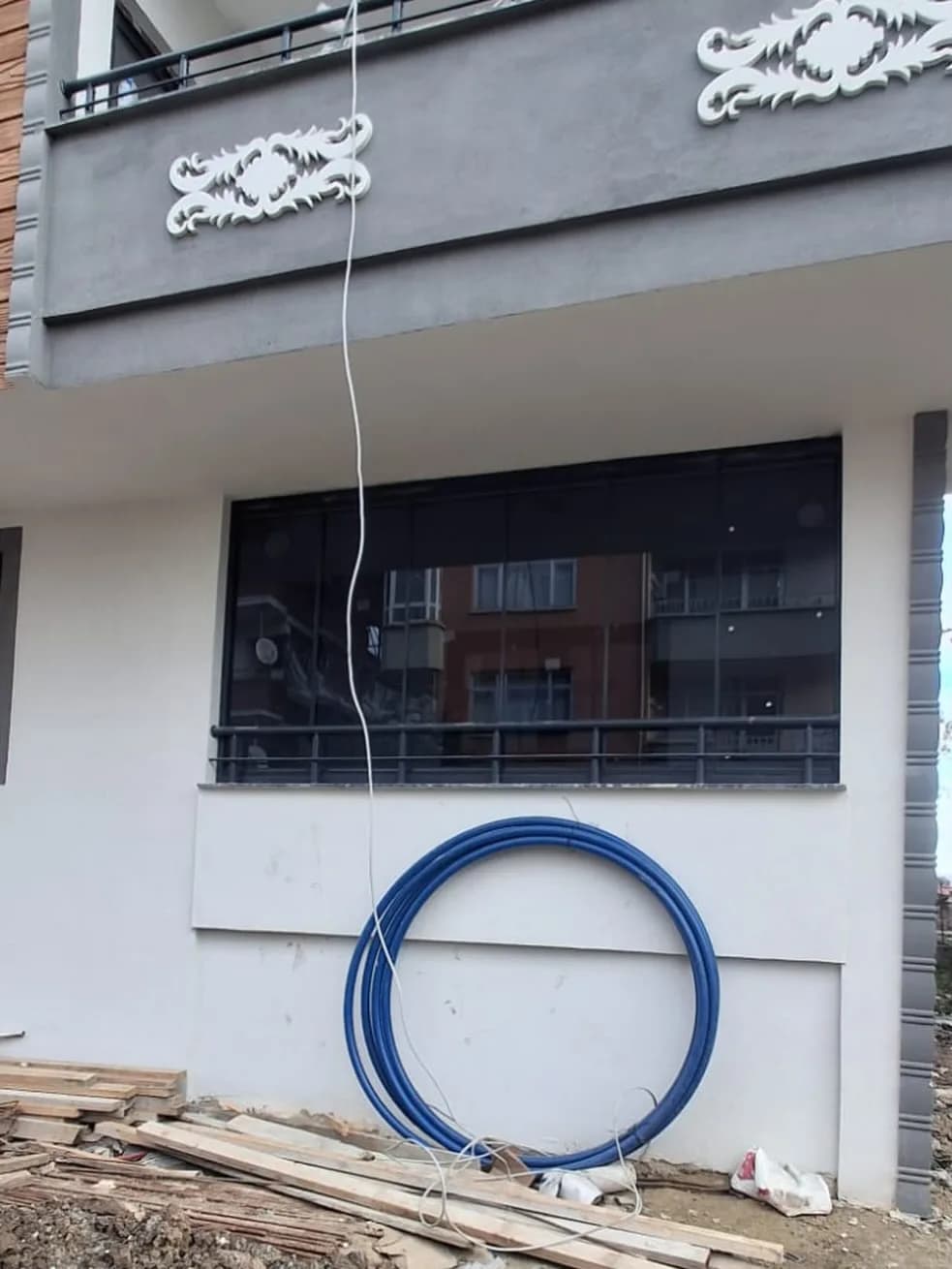 Samsun'da bina cephesine uygulanmış koyu çerçeveli ısıcamlı cam balkon sistemi