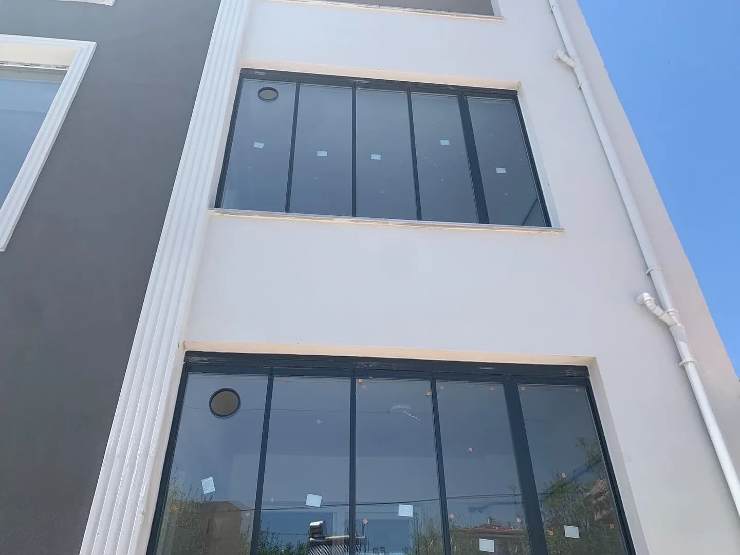 Samsun'da bina cephesine uygulanmış siyah doğramalı füme sürme cam balkon sistemi