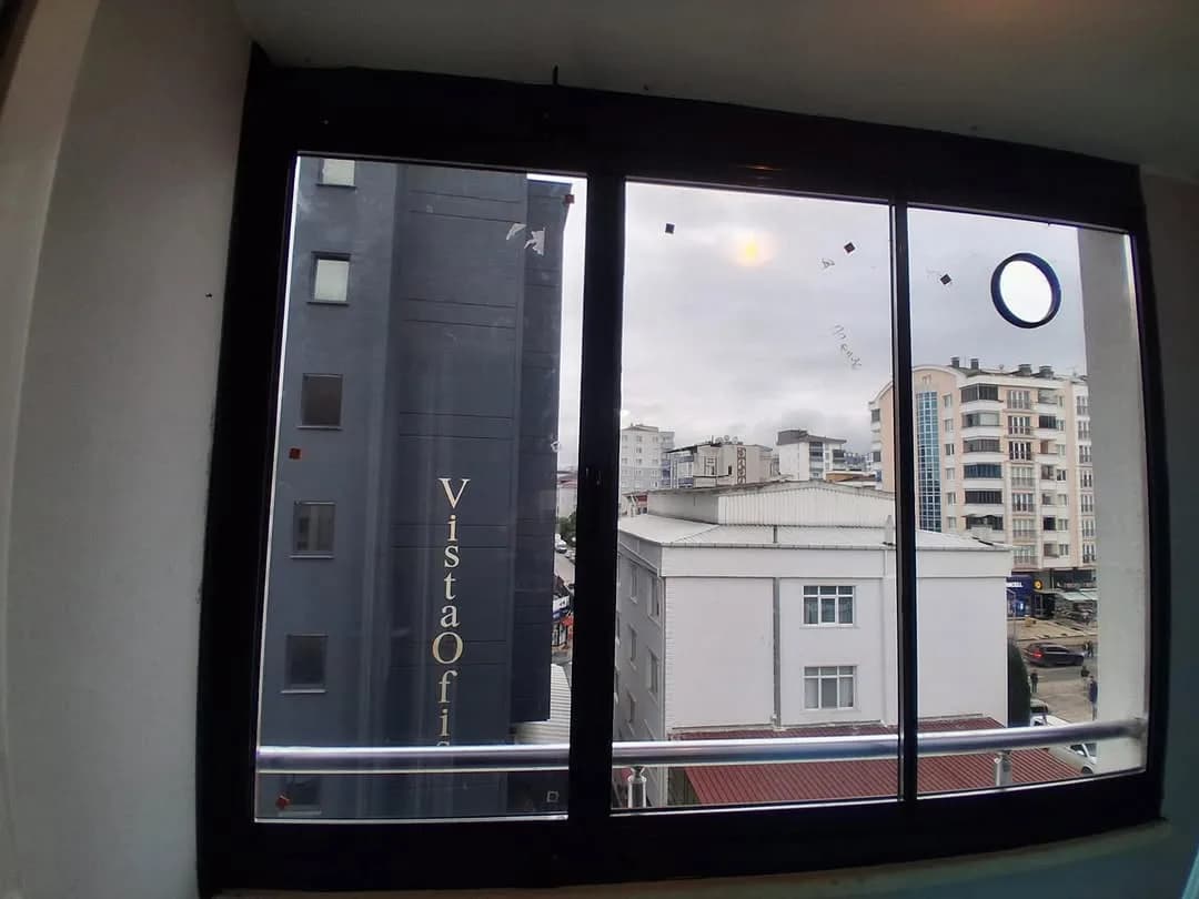 Samsun'da bir daireye uygulanmış, şehir manzaralı ince siyah çerçeveli sürme cam balkon sistemi