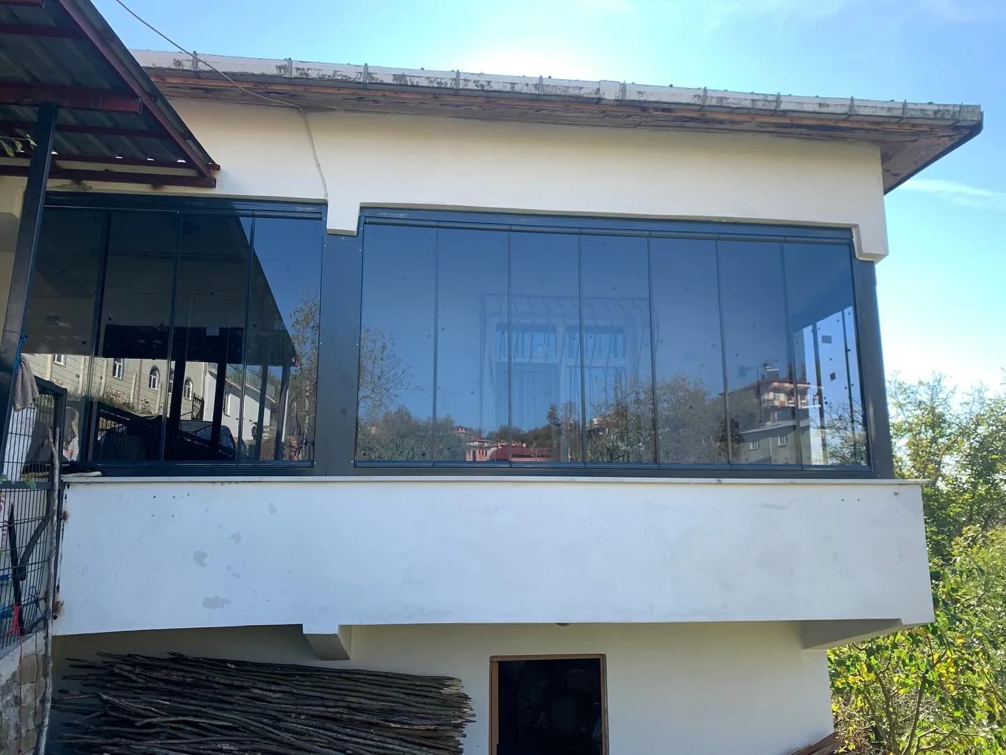 Samsun'da bir evin üst kat balkonuna uygulanmış füme camlı katlanır cam balkon sistemi