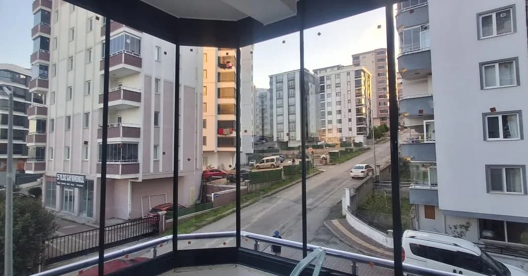 Samsun'da köşe balkona uygulanmış çerçevesiz katlanır cam balkon sistemi, sokak manzaralı