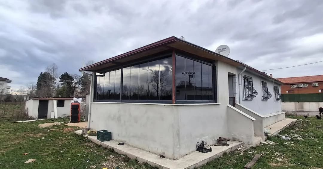 Samsun'da müstakil ev köşesine uygulanmış antrasit çerçeveli katlanır cam balkon sistemi
